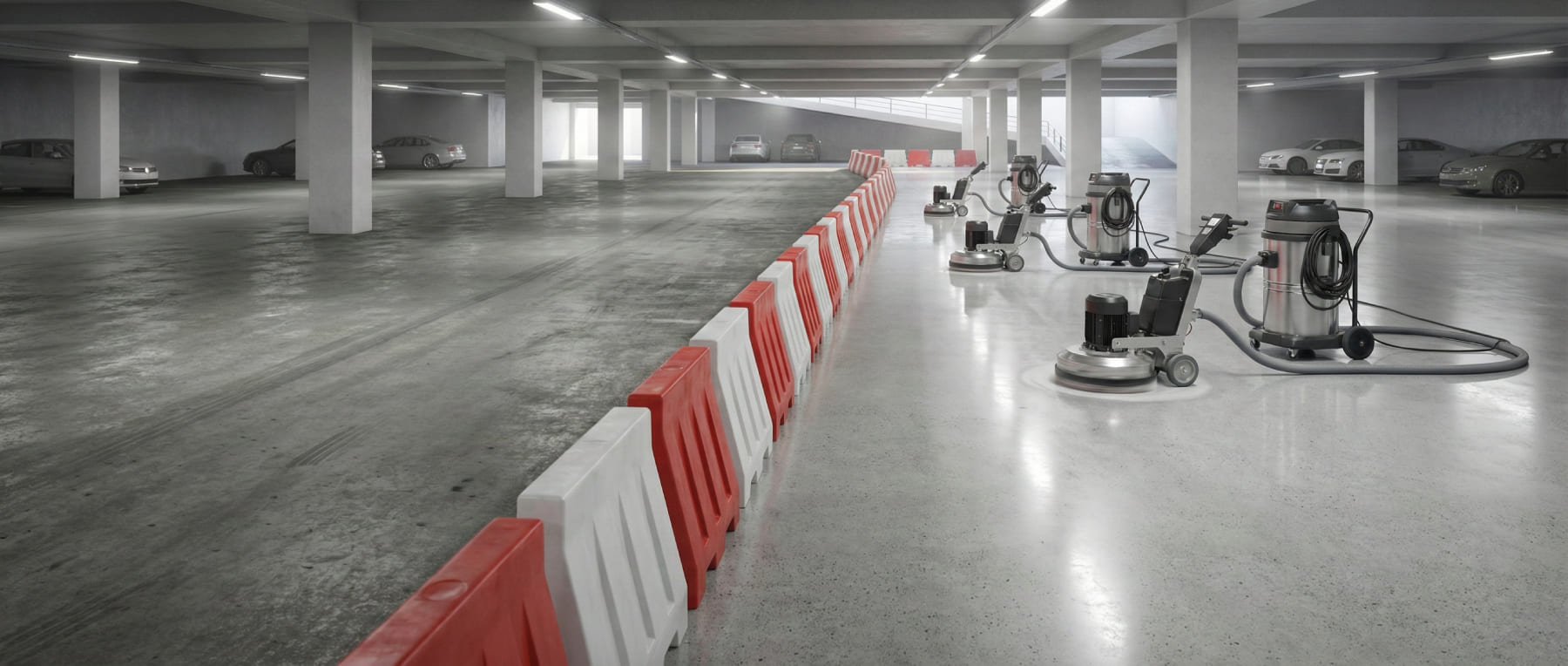 Innenansicht einer Tiefgarage während der Sanierung mit rot-weißen Barrieren zur Abtrennung der Baustelle und mehreren Bodenschleifmaschinen auf der bearbeiteten Fläche - Visualisierung von High-Speed-Performance im laufenden Betrieb.
