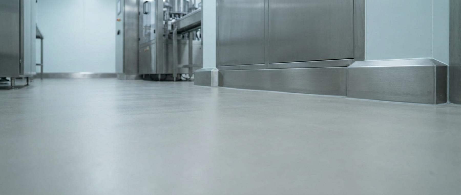 Froschperspektive eines sterilen Reinraums mit Edelstahlanlagen und fugenlosem Boden - Visualisierung von Hygienevorschriften in der Pharma- und Lebensmittelindustrie.
